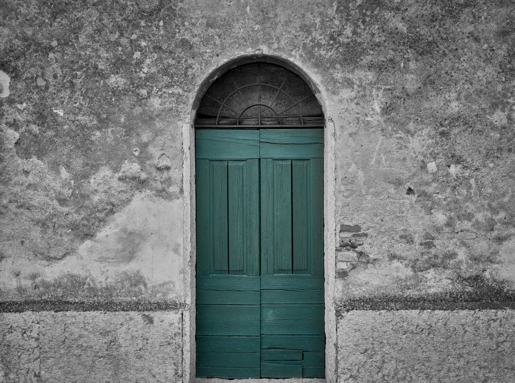 Grön dörr i gammal vägg