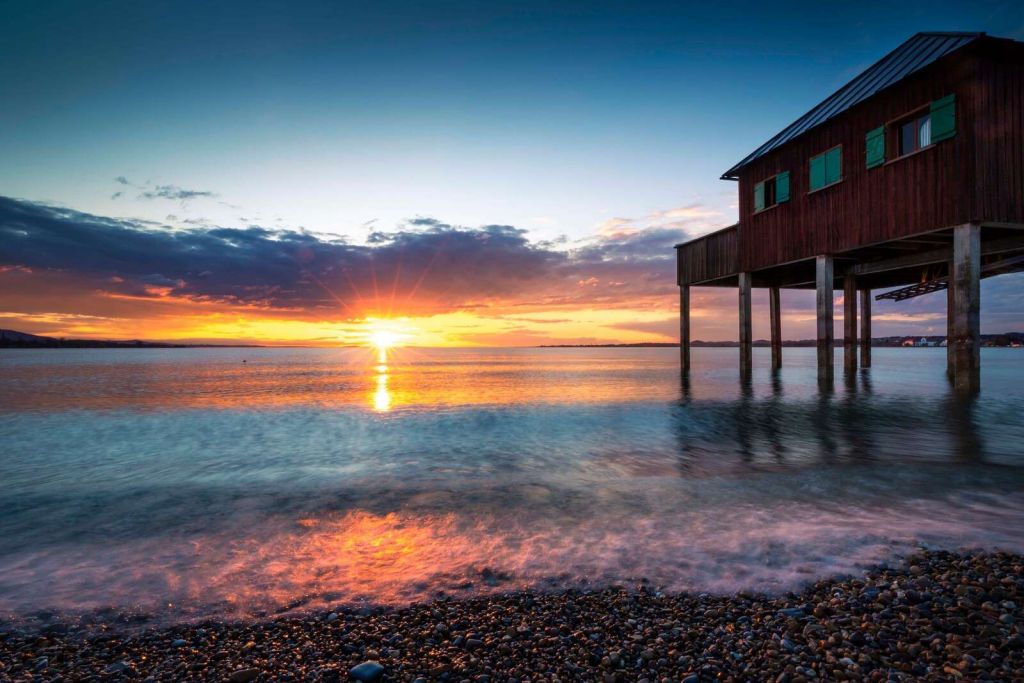 Solnedgang ved rolig badehus
