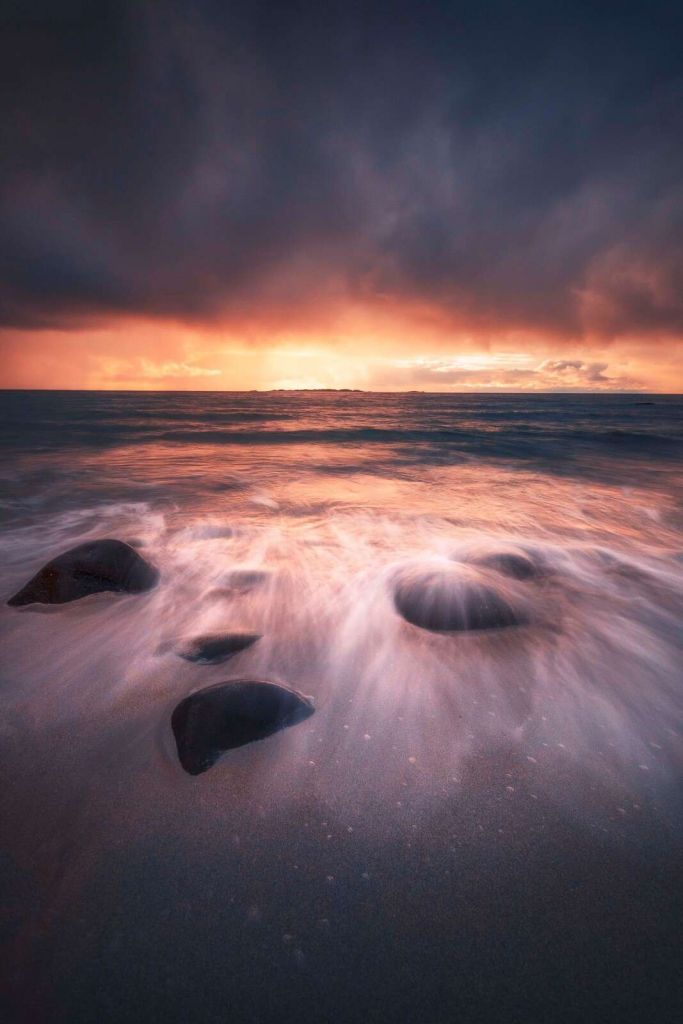 Aftenrød over stenet kystlinje