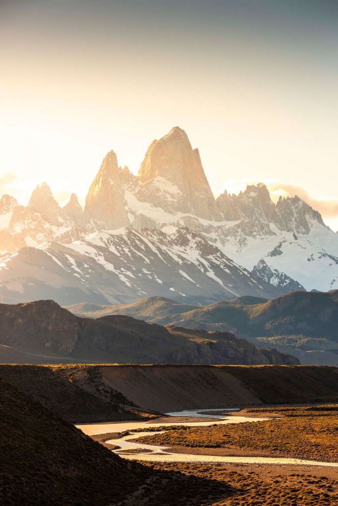 Gylden solopgang i bjergdal.