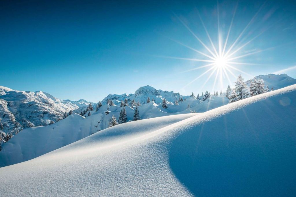 Sollys over glitrende sneeuwtoppe