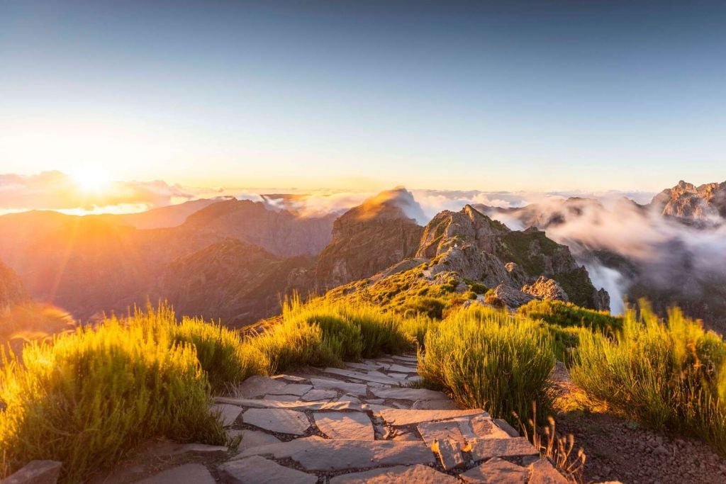 Solopgang over bjergsti og skyer