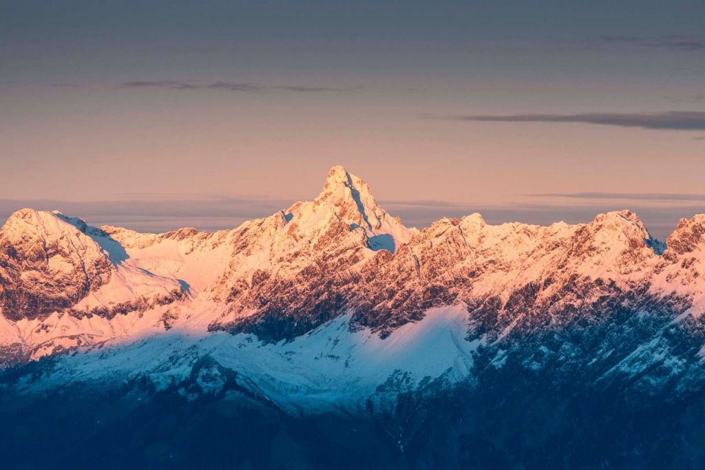 Aftenlys over sneklædte bjergtoppe