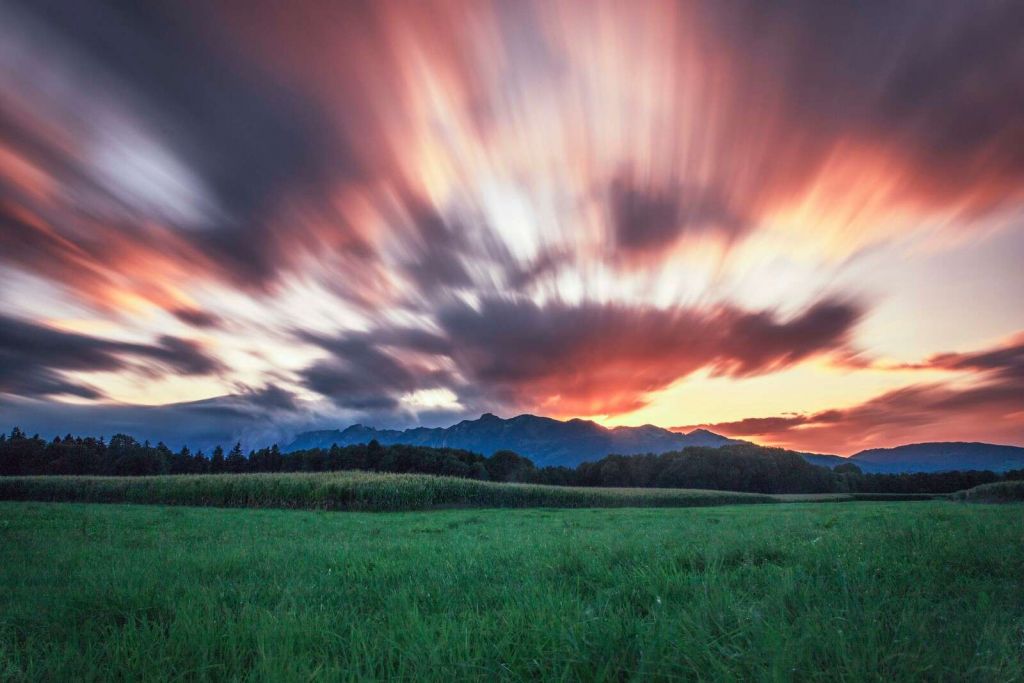 Solnedgang over grøn slette