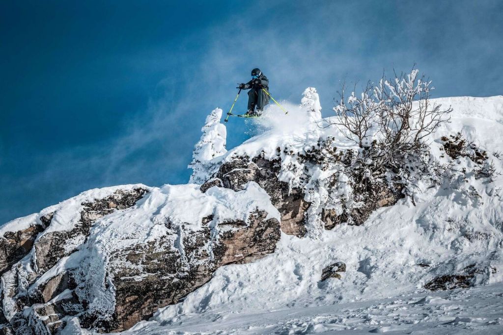 Freestyle skiløper i snødekt fjellverden