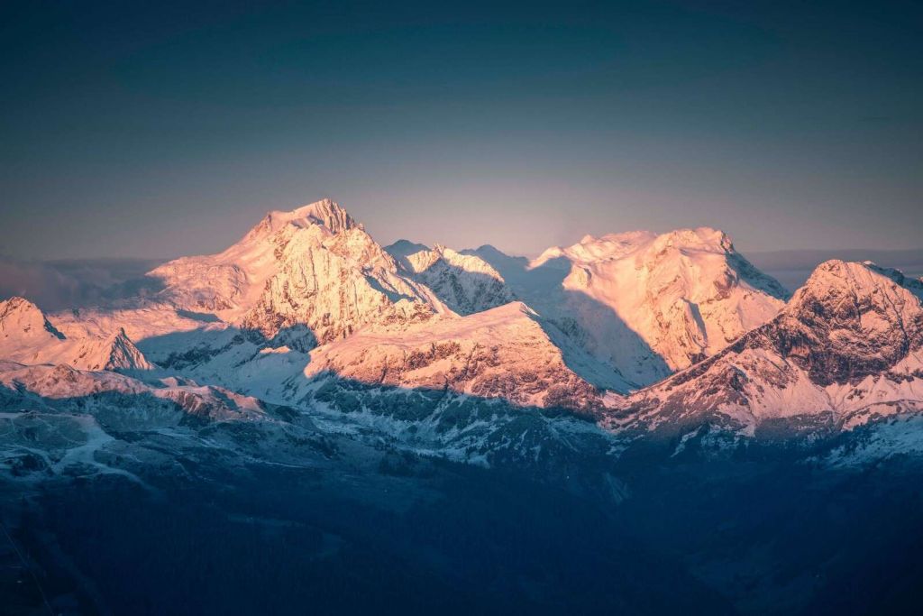 Morgensol på snødekte fjelltopper