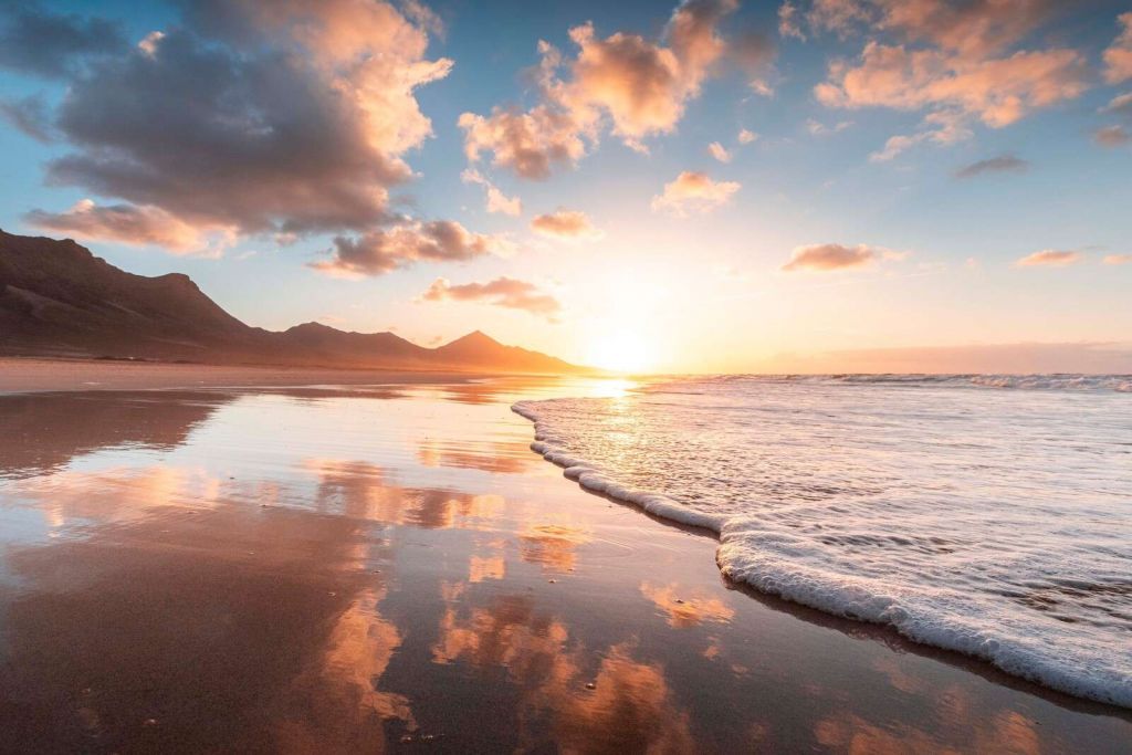 Gylden solnedgang ved stille kyst.