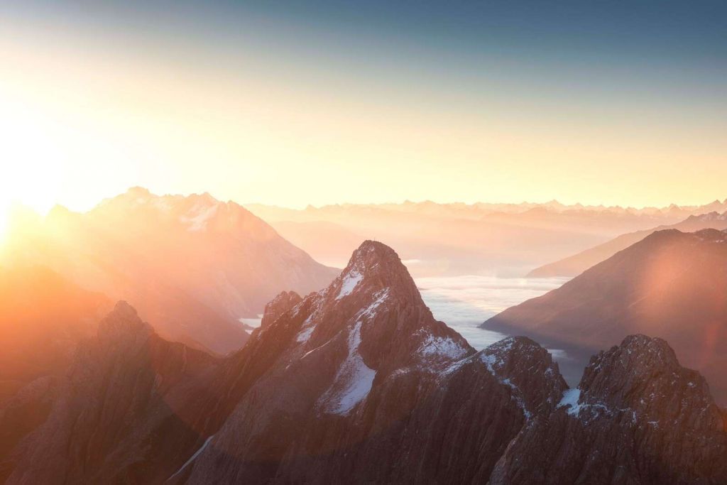 Soloppgang over fjellsilhuetter