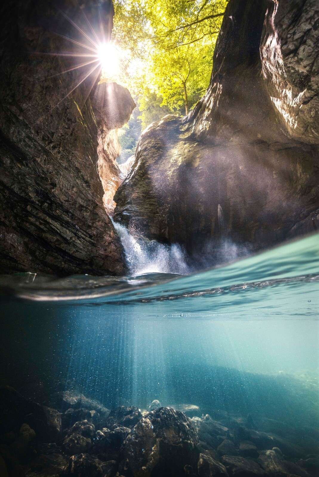 Sollys i fjellkløft med foss