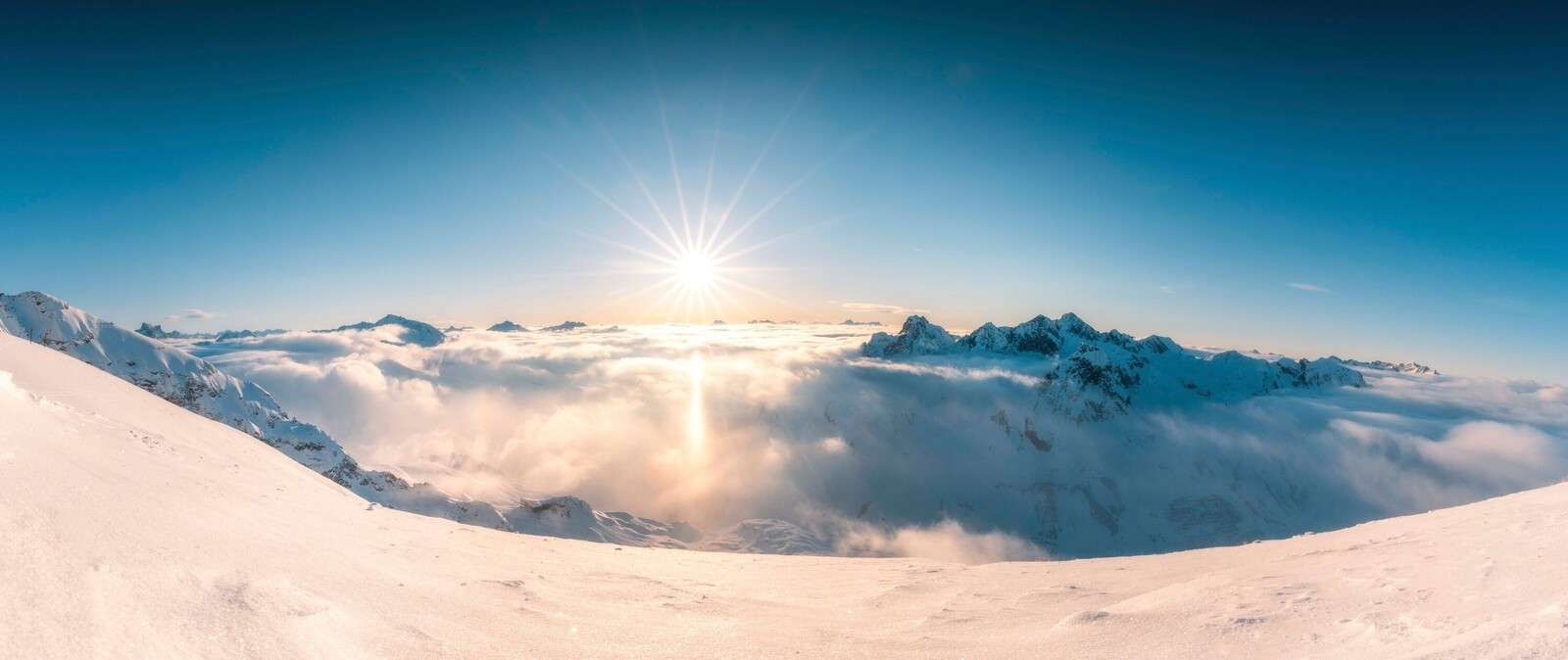 Sonen over skydekket i alpepanoramaet.