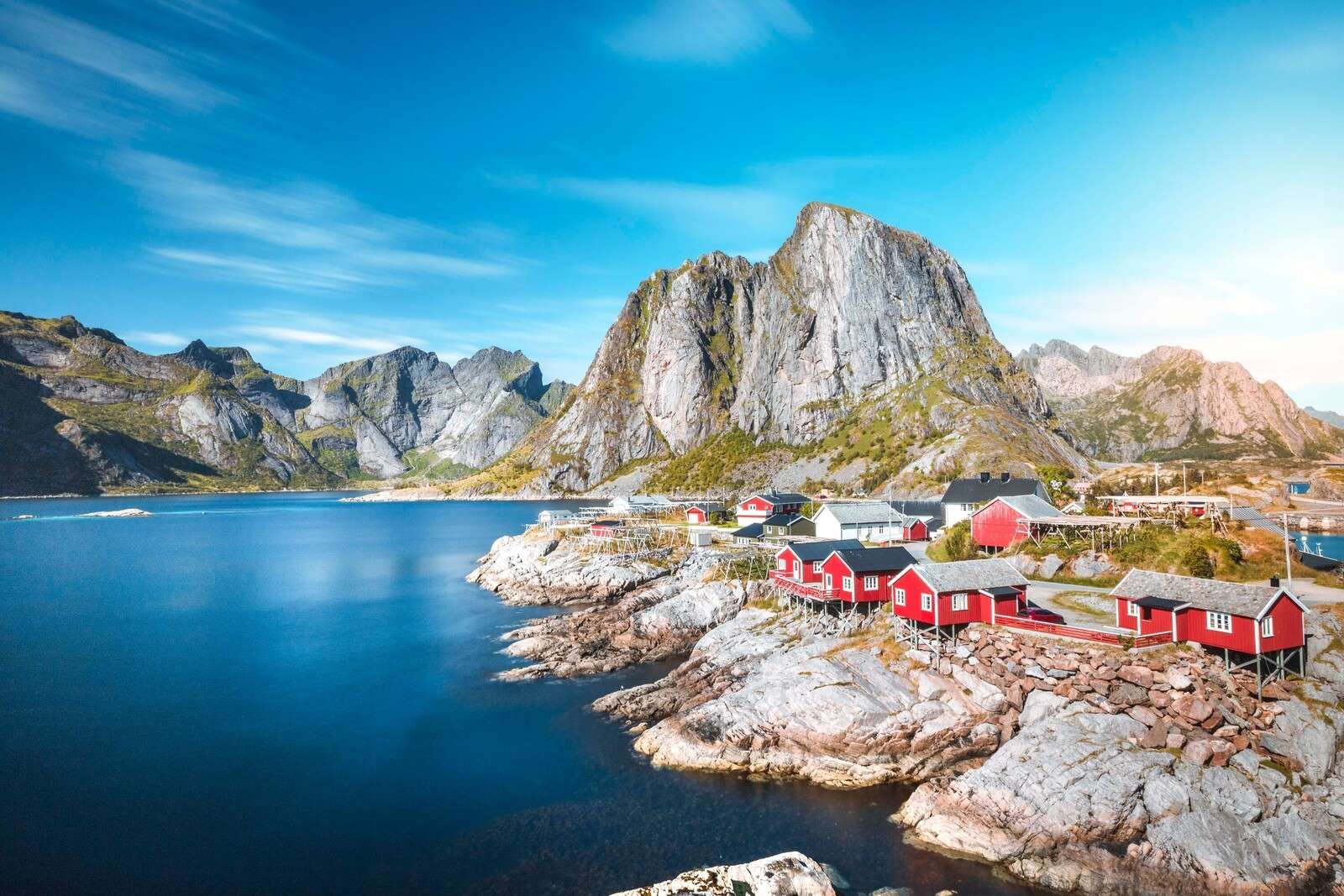 Röda fiskarstugor vid norsk fjord.