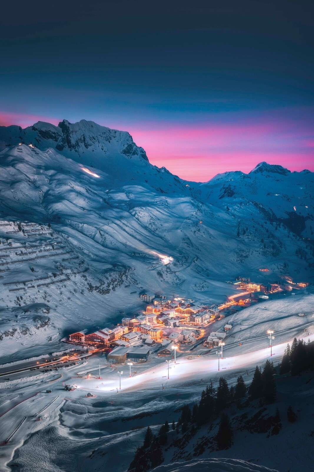 Snedækket landsby under lilla aftenhimmel