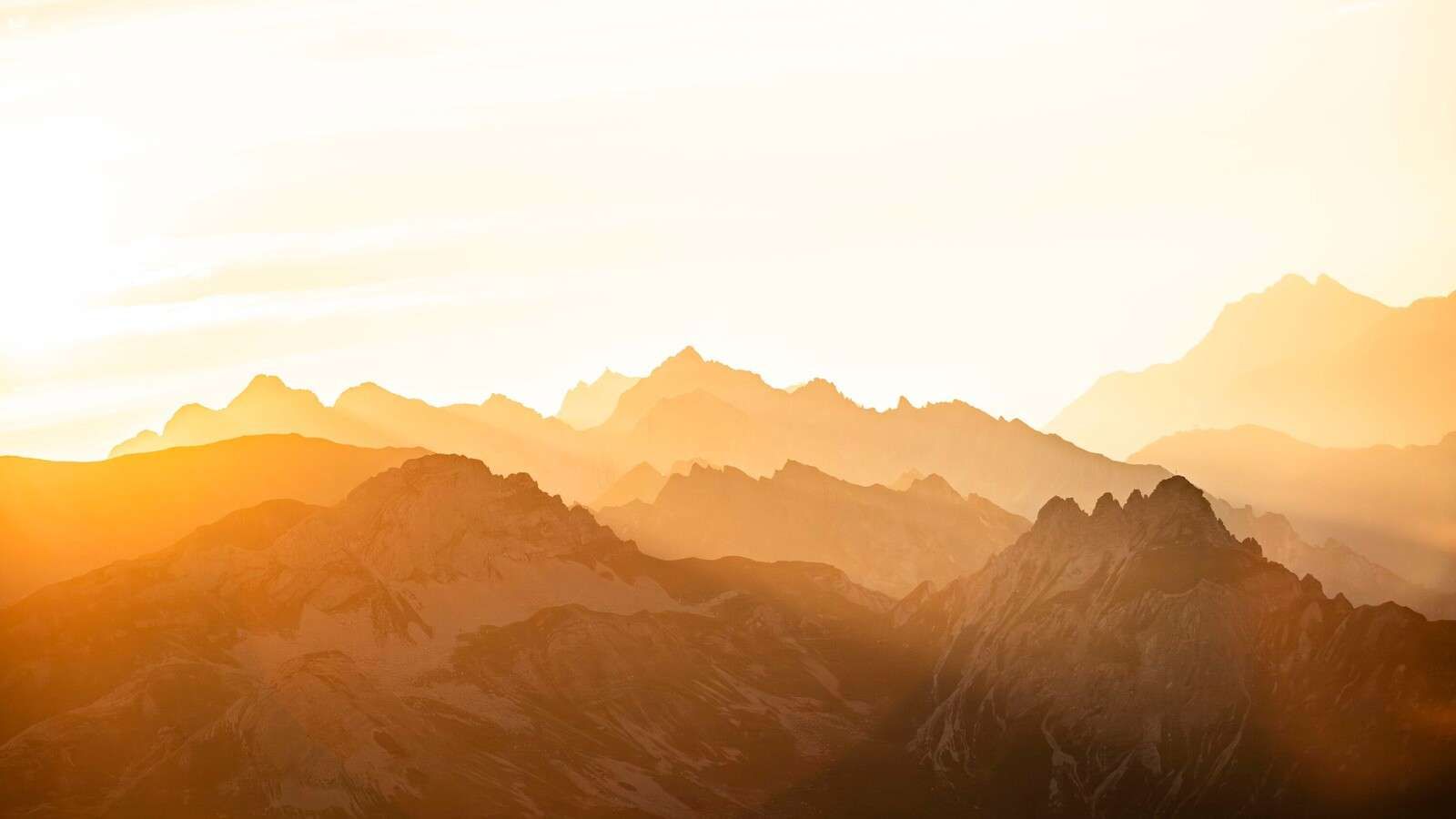 Gyldne bjerge ved solopgang.