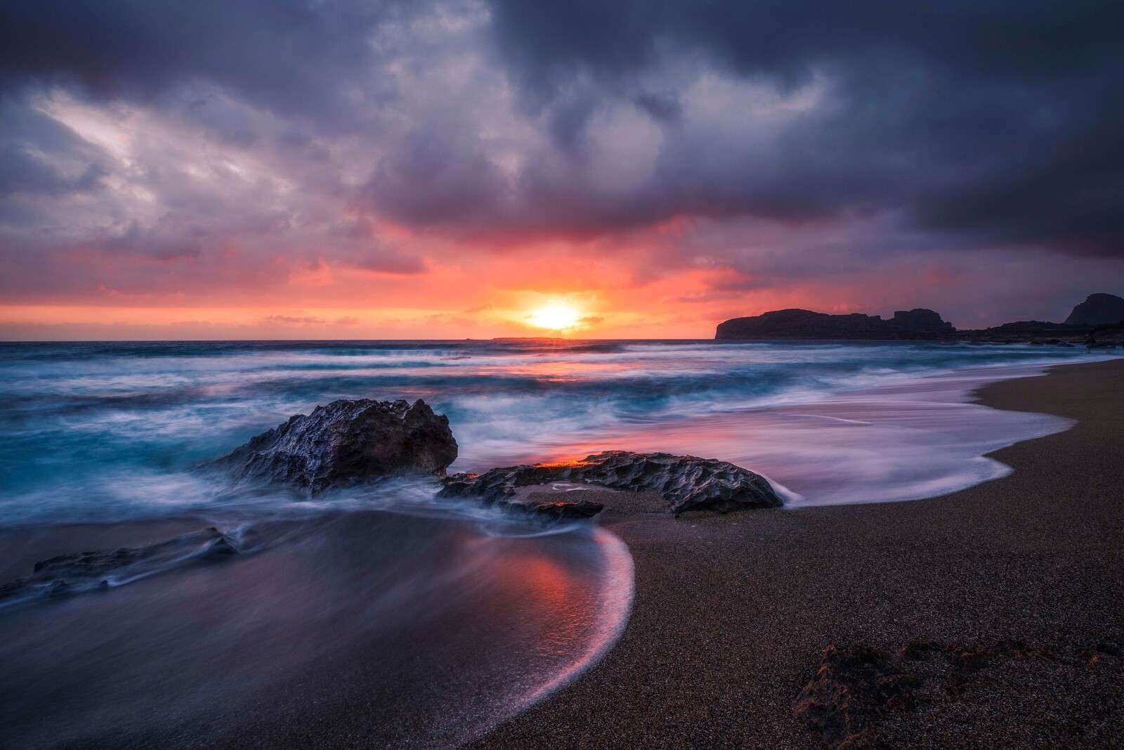 Klippig kust vid solnedgången.