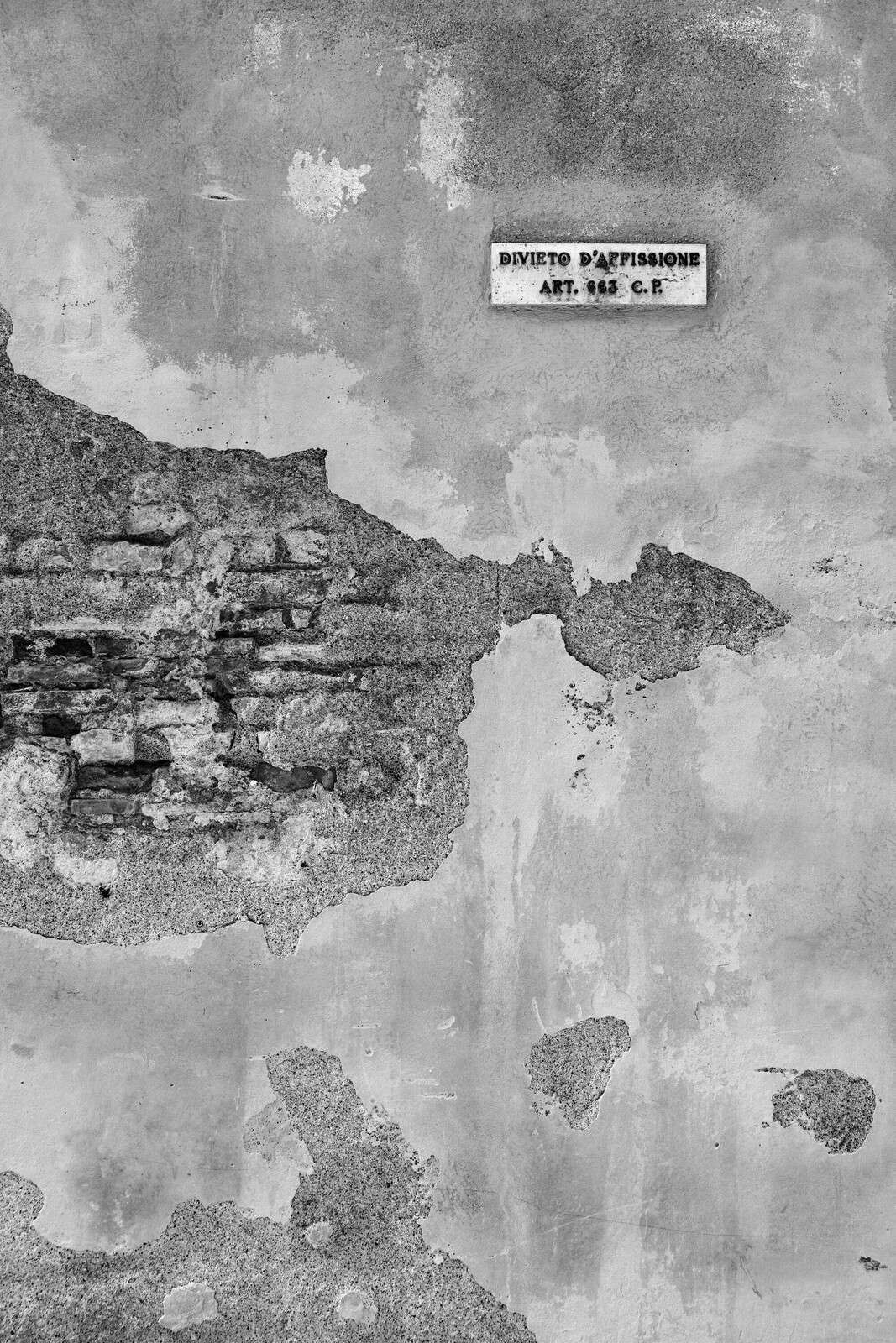 Forvitret mur med italiensk tekst